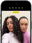 iPhone 18 Pro, black, front exterior, displaying two models posing for the camera, demonstrating the Center Stage front camera