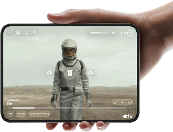 iPhone Duo, held with one hand, opened in horizontal orientation, fully unfolded, interior screen displays Apple TV show "Silo"