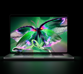 MacBook Pro with PROLED XDR Display, open lid, silver colour, display shows detailed, high-contrast image with vivid colours, screen illuminates keyboard