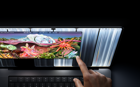 MacBook Pro with PROLED XDR Display, space black colour, user resizes a window on screen with their fingertip